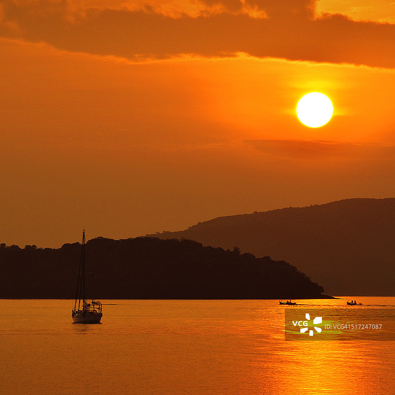 在温暖的光线下在海上航行的帆船图片素材