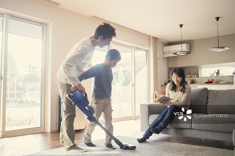 父子在家用吸尘器打扫卫生图片素材