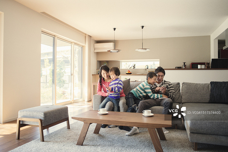 全家在家一起使用平板电脑和智能手机图片素材