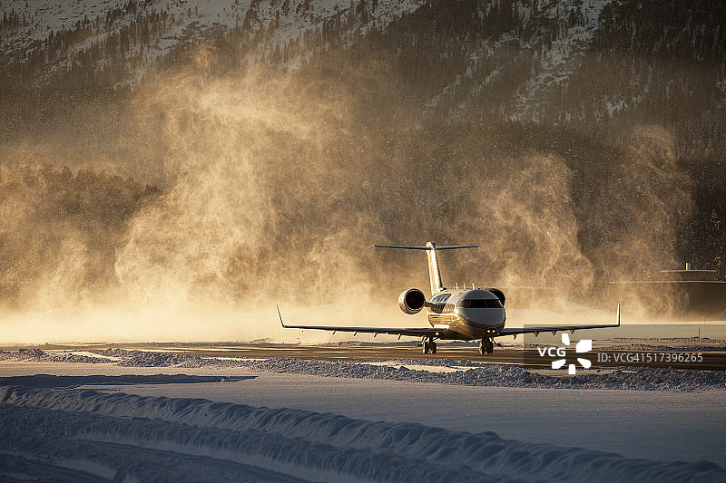 公务机从白雪皑皑的机场起飞图片素材