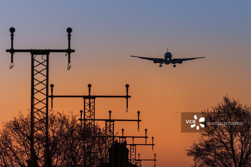 日出时分降落的商用客机图片素材