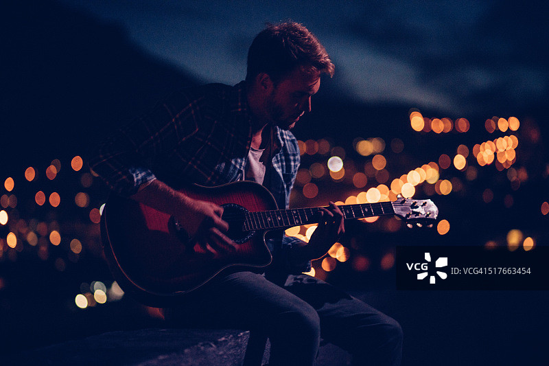 年轻男人在城市中弹吉他图片素材