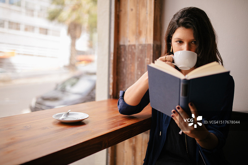 女孩在咖啡馆喝咖啡看书图片素材