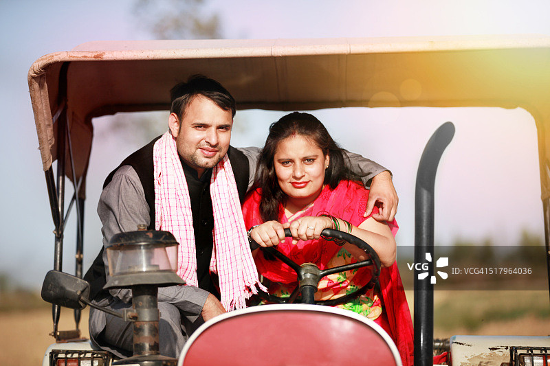 女农民驾驶旧拖拉机穿过田野图片素材