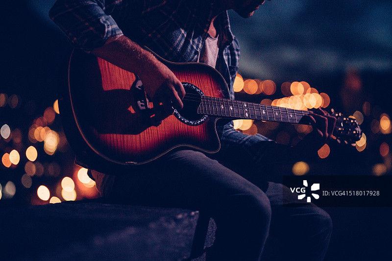 时髦吉他手在屋顶上演奏图片素材