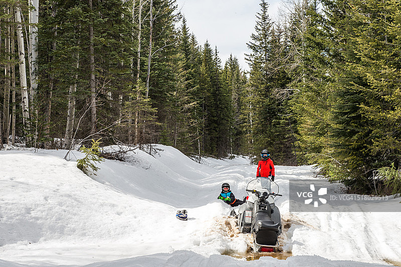 两个男孩与雪地摩托事故图片素材