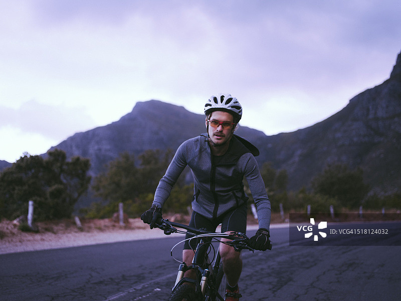 骑行者在山路上比赛的正面照。图片素材