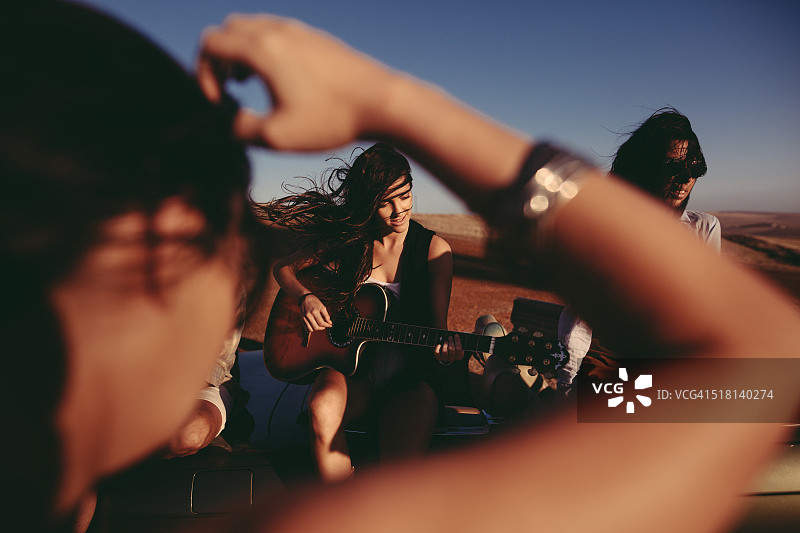 朋友们在公路旅行中唱歌跳舞，带着吉他图片素材