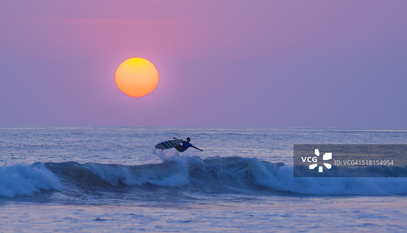 冲浪者在圣特雷莎卡门海滩日落时跳跃图片素材