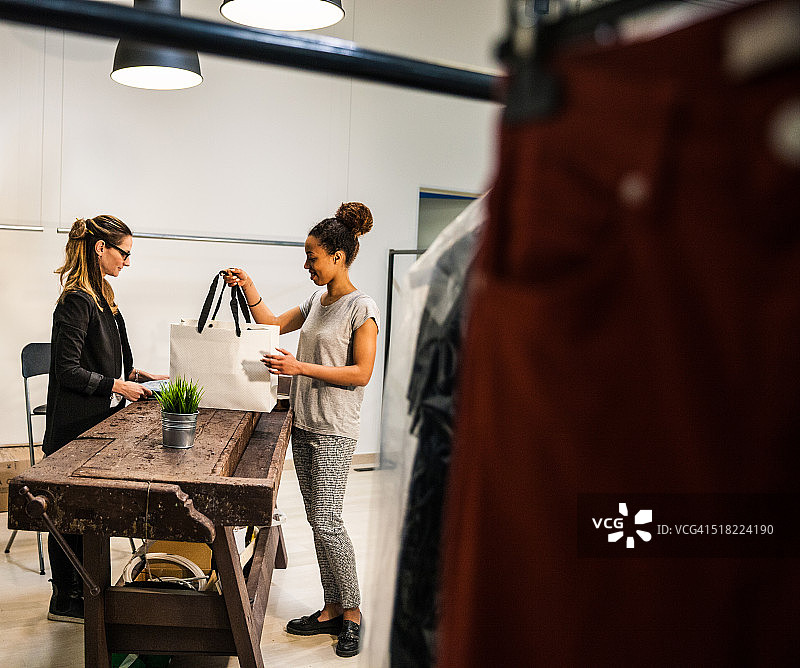 女售货员帮助顾客选择商品图片素材