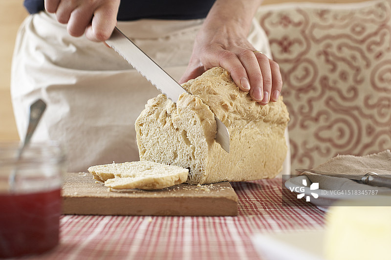 女人在砧板上切割自制酵母面包，局部视图图片素材