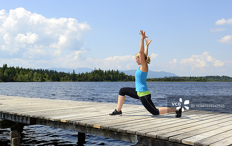 德国巴伐利亚萨克森卡姆：女人在海边码头上进行功能训练图片素材