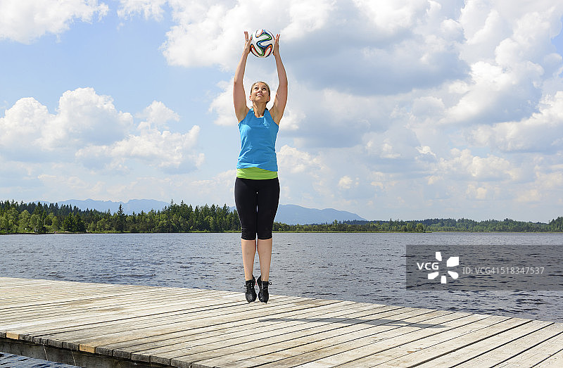 德国巴伐利亚萨克森卡姆：女人在海边码头上进行功能训练图片素材
