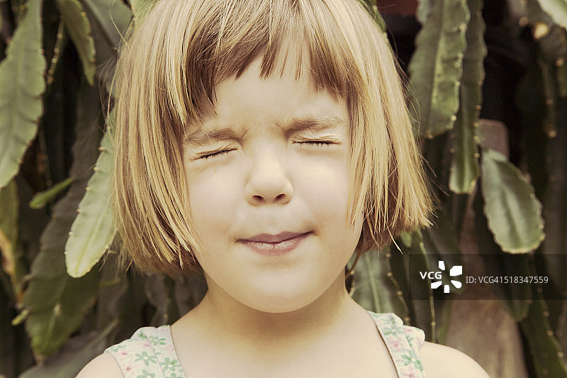 闭着眼睛嘟着嘴的小女孩肖像图片素材