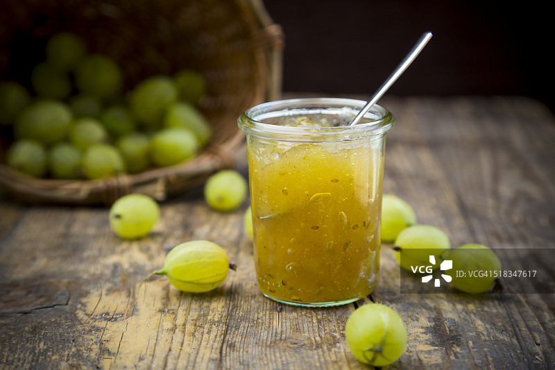 醋栗果酱罐、篮子和有机醋栗深色木纹背景图片素材