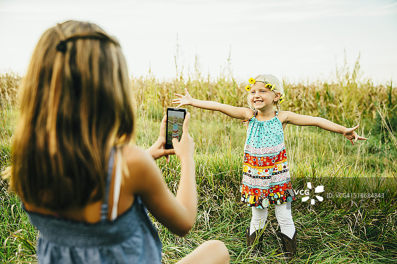 女孩在户外给妹妹拍照图片素材