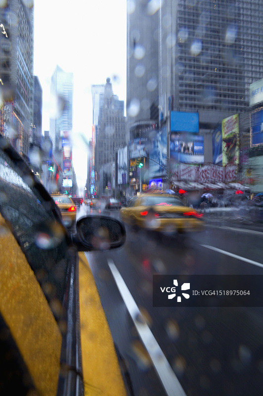 透过潮湿镜头看到的黄色出租车图片素材