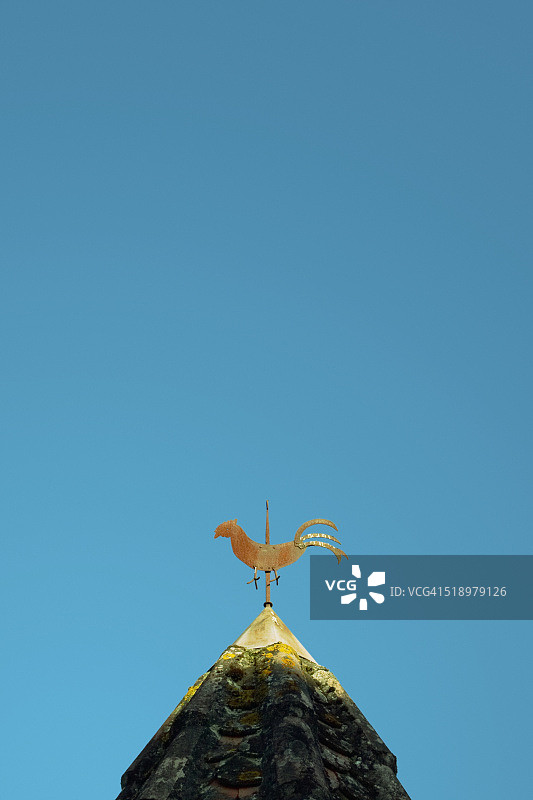 仰视：屋顶上的风向标，背景是蓝天图片素材