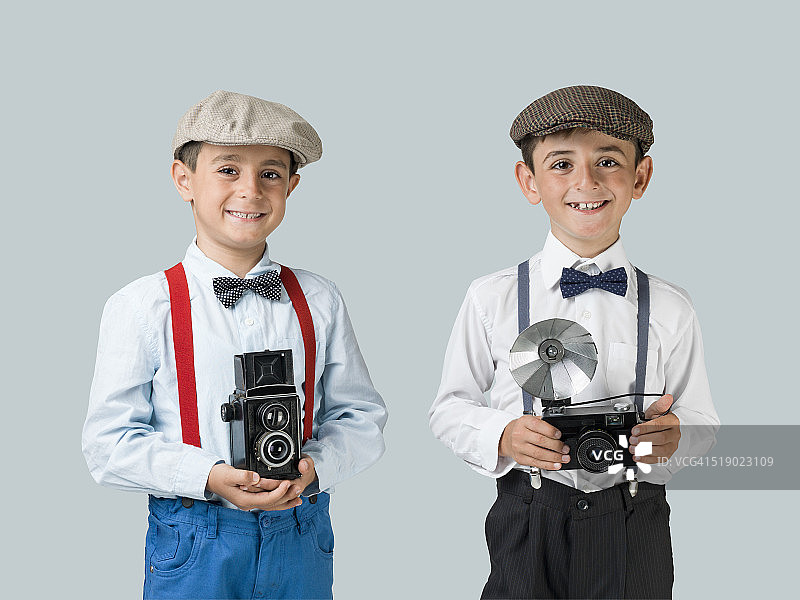 手持老式相机的小摄影师图片素材