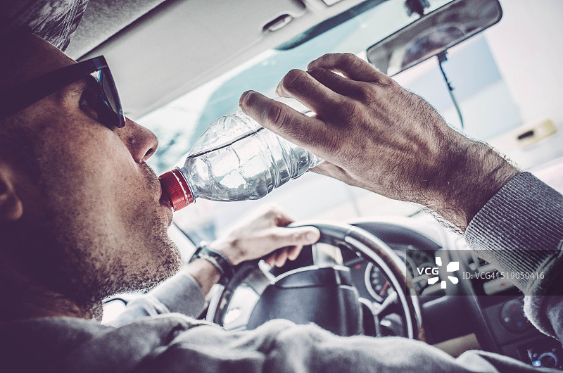 男人开车喝水肖像图片素材