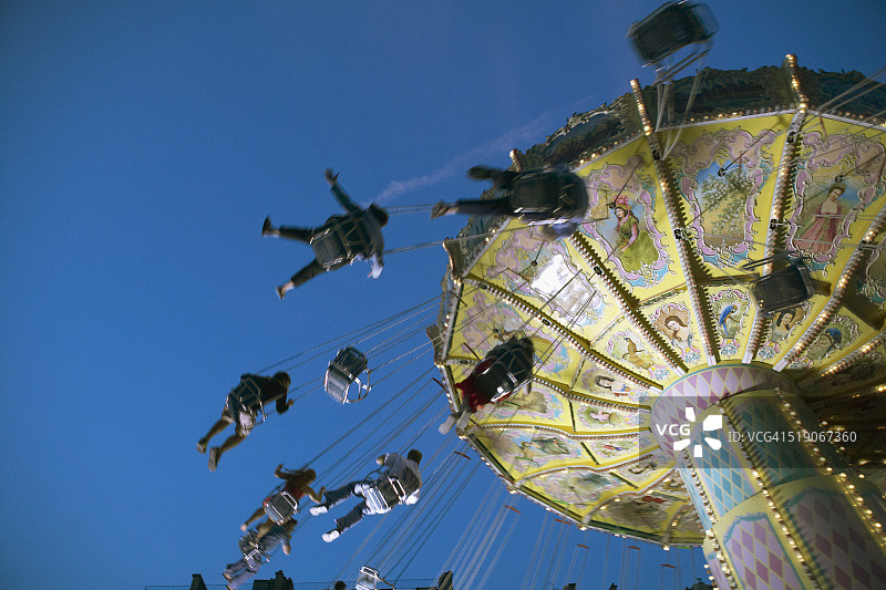 蓝天下旋转的游乐园设施图片素材