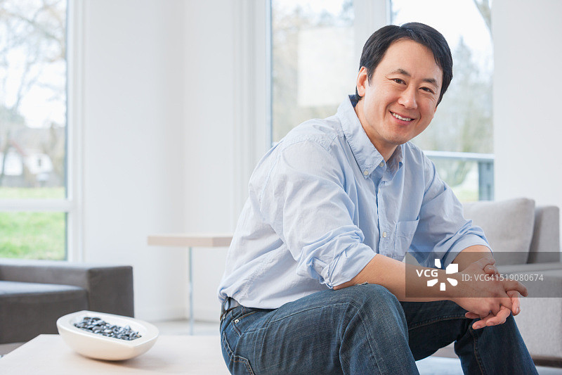 客厅里的中年亚洲男人图片素材