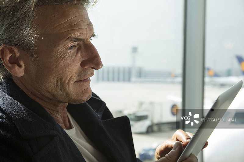 男子在机场大厅使用平板电脑图片素材