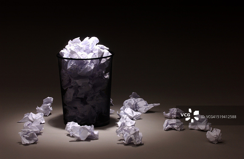 周围散落着纸张的废纸篓图片素材