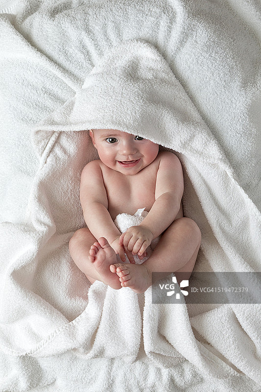 微笑的婴儿躺在毯子上图片素材