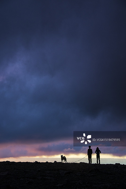 暴风云下的徒步者和狗图片素材