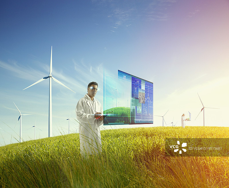 在风力涡轮机田中使用全息屏幕的混血科学家图片素材