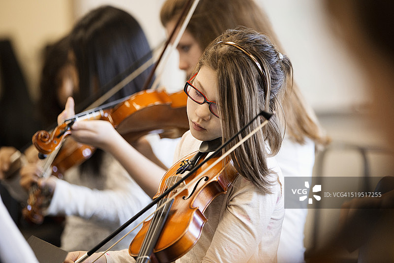 白人女孩在音乐课上演奏小提琴图片素材