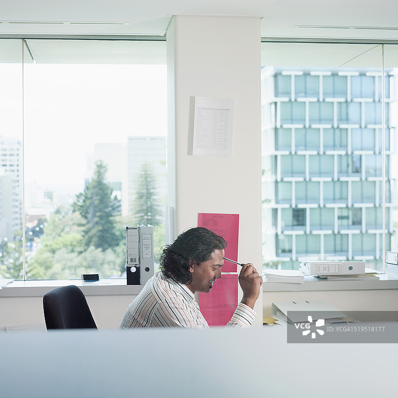 在办公室办公桌前思考的亚洲商人图片素材