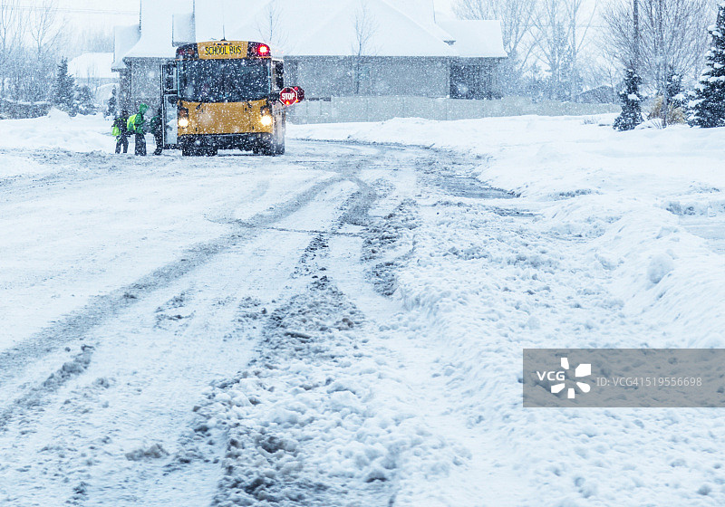 学生们冒着暴风雪登上校车图片素材