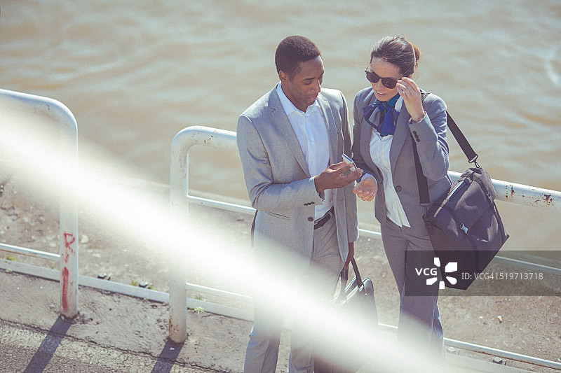 年轻男人和女人在水边愉快交谈图片素材