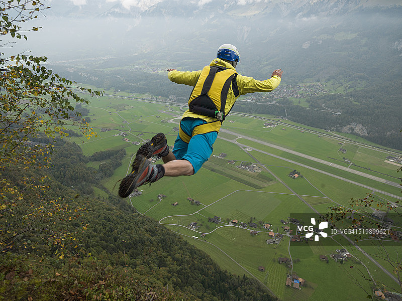 悬崖跳伞者在山谷中进行空中飞行图片素材