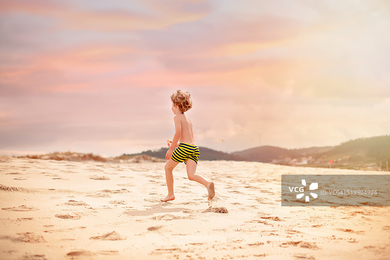 在海滩奔跑的男孩图片素材