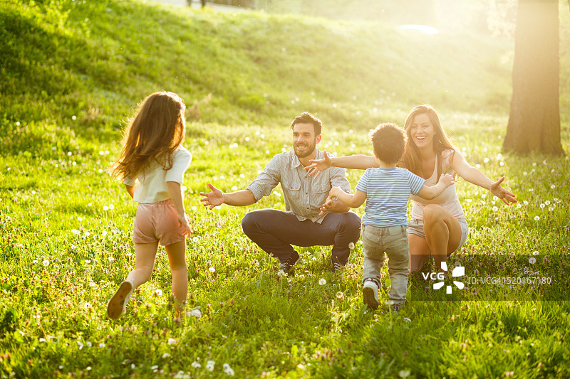 两个孩子在公园里奔向父母图片素材