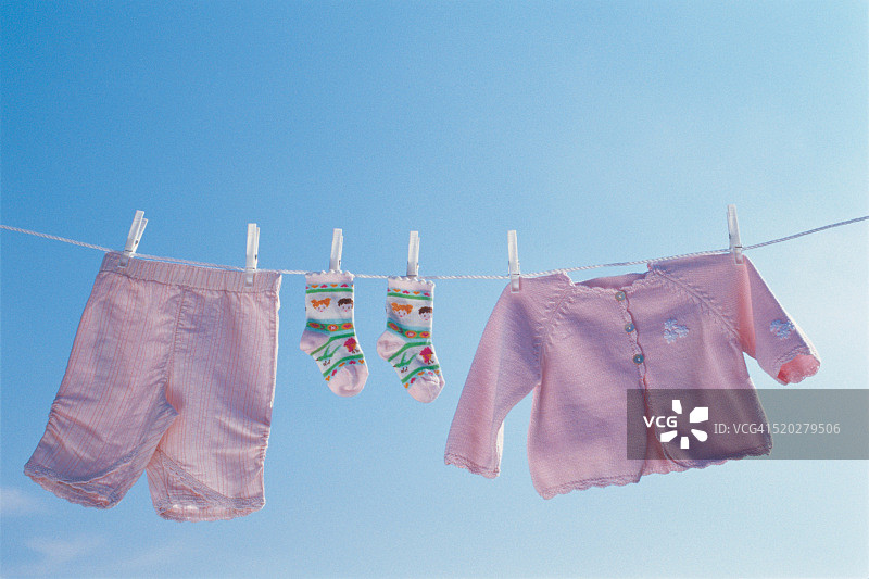 挂在晾衣绳上的婴儿衣服图片素材