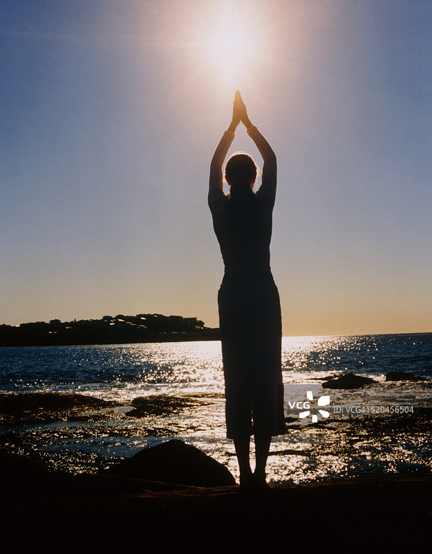 在海边做瑜伽的年轻女人图片素材