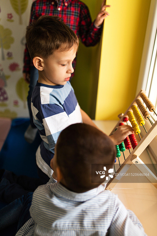在幼儿园玩算盘的小男孩图片素材