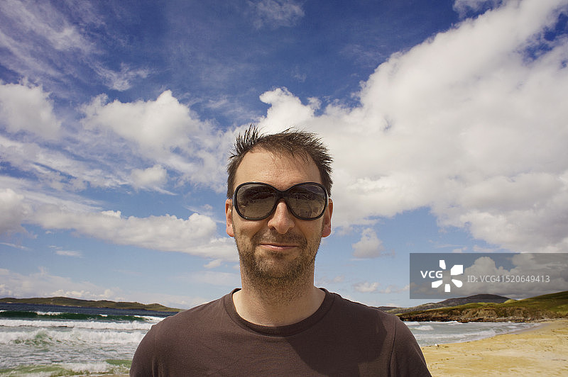 男子在苏格兰岛屿海滩上微笑图片素材