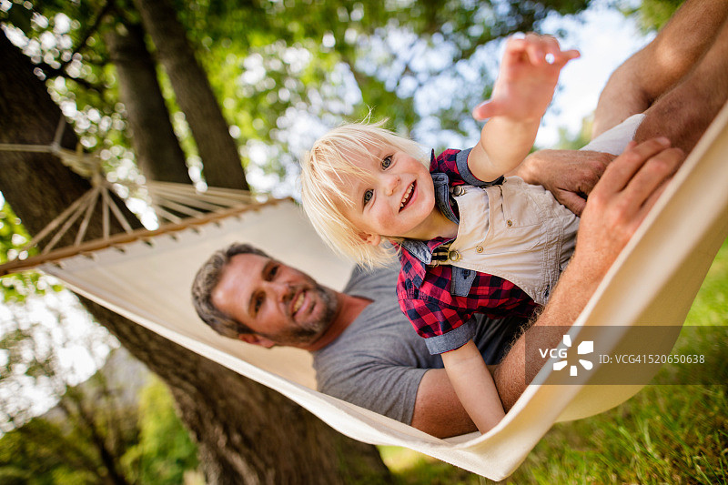 父亲和金发孩子在吊床上玩耍图片素材