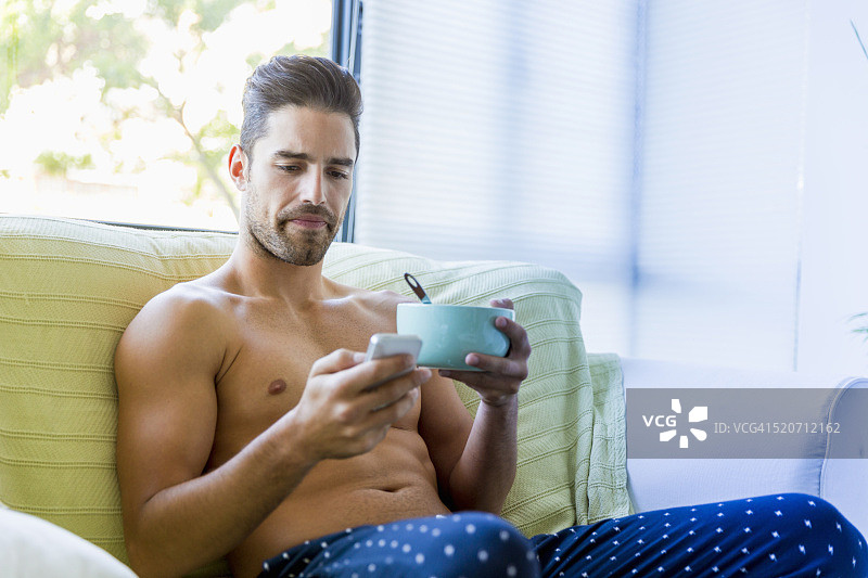 男人用手机同时享用早餐图片素材