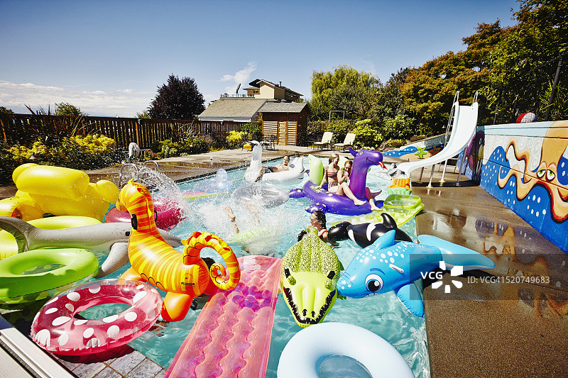 朋友们在泳池派对上玩充气玩具图片素材