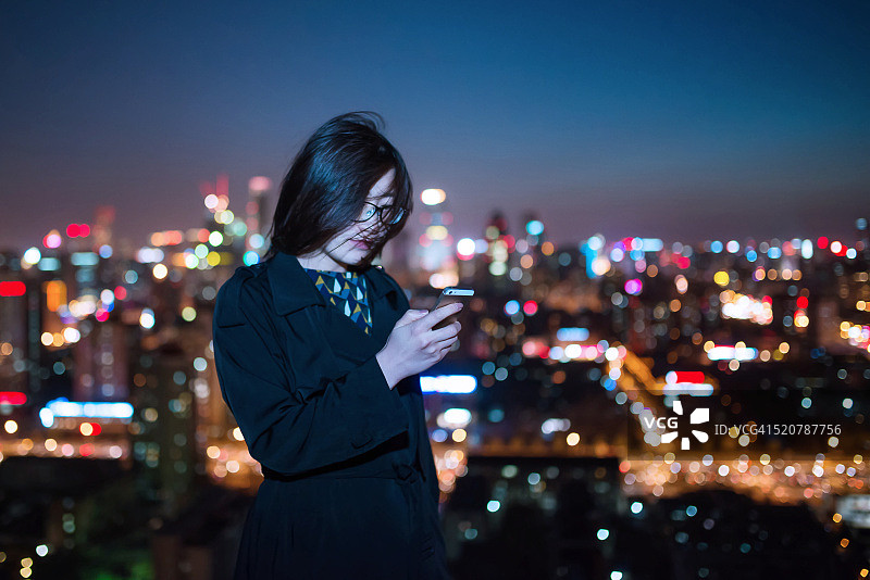 在市中心使用手机的亚洲女孩图片素材