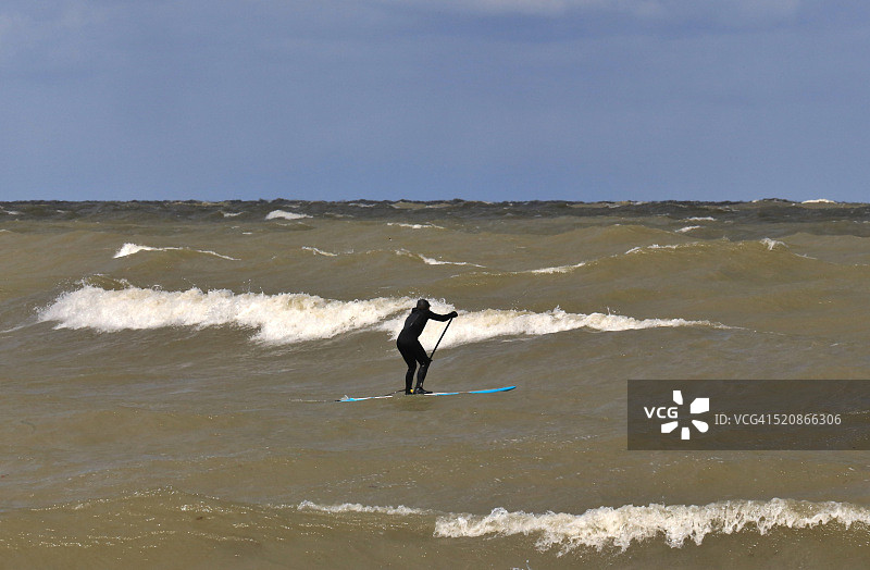 在伊利湖冰冷的水面上进行桨板比赛的人图片素材