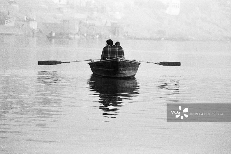 1982年，印度北方邦瓦拉纳西，情侣在恒河上裹着毯子划船图片素材