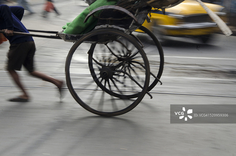 在印度西孟加拉邦，男人用人力车运送乘客图片素材