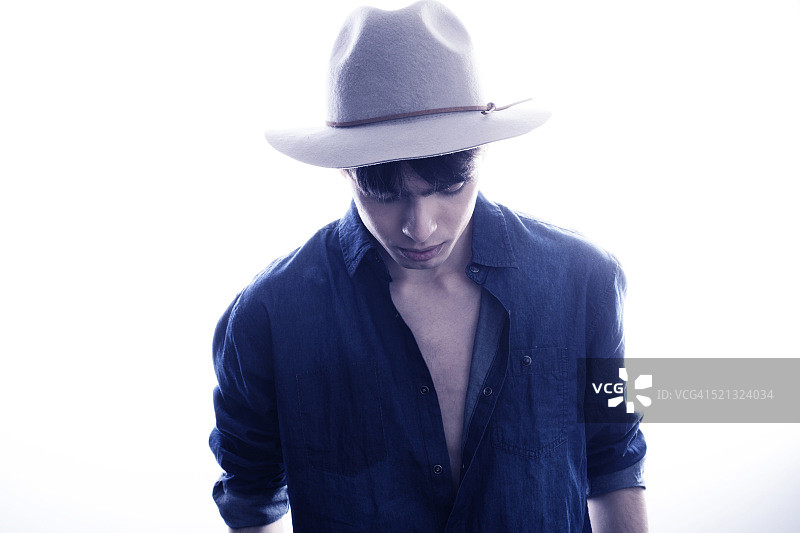 戴帽子的时尚男孩在工作室摆姿势图片素材